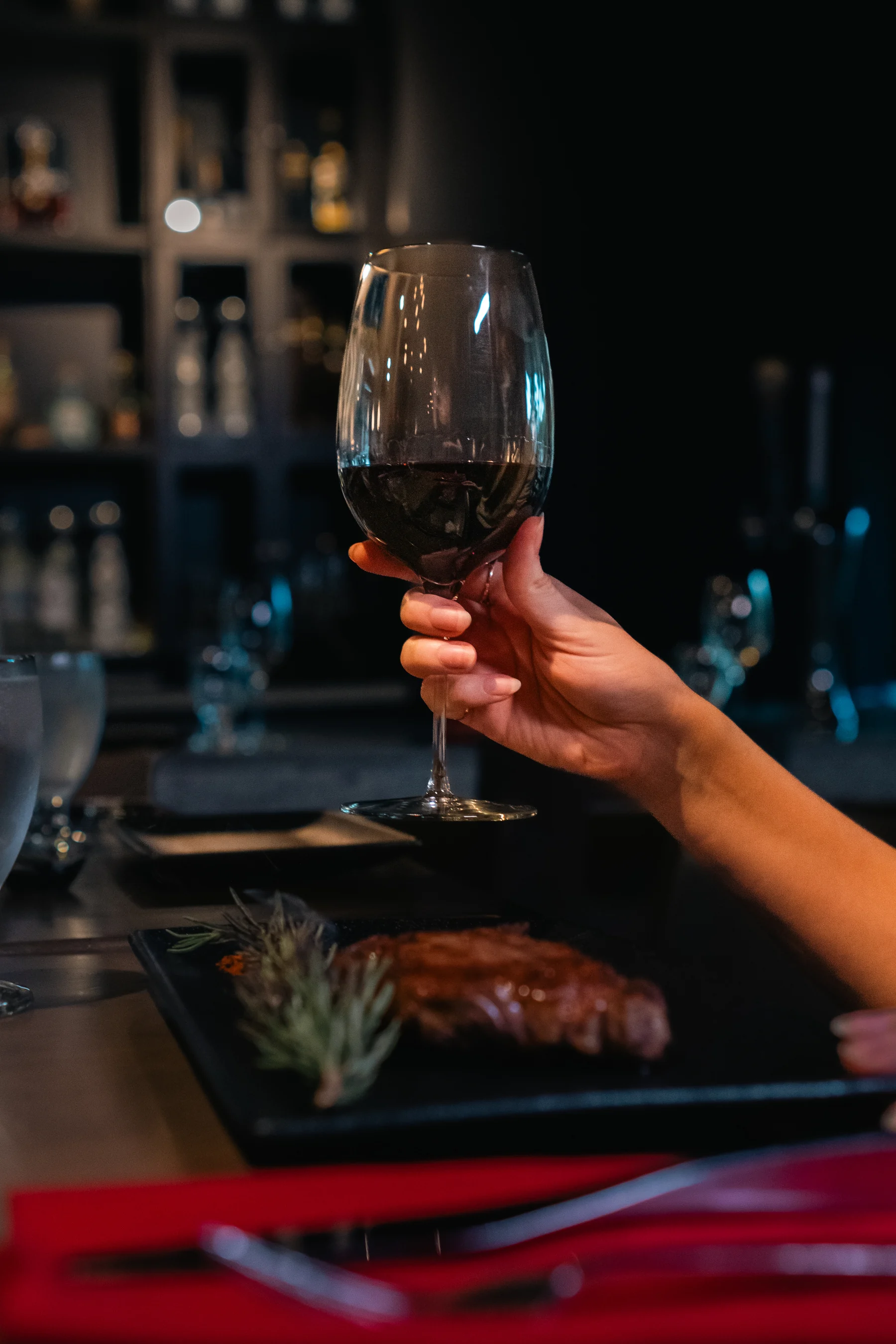A guest holding a glass of wine at Prime