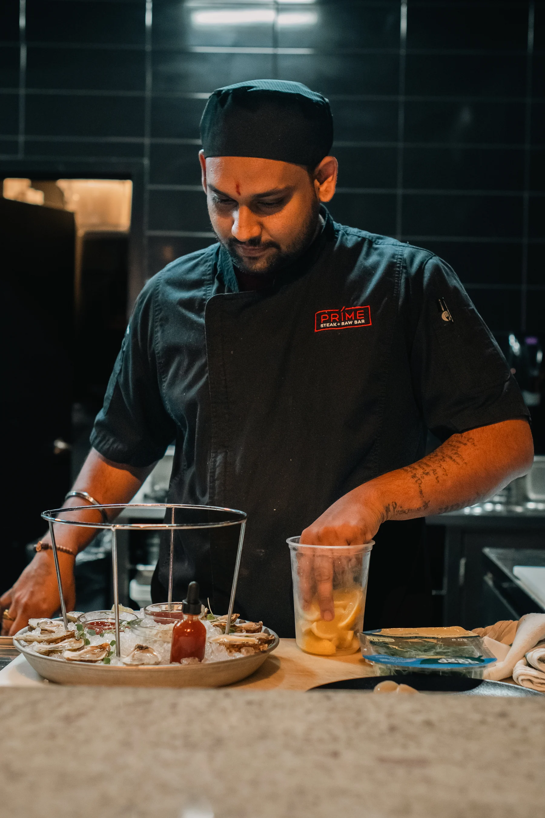 A member of Prime’s kitchen team prepares a raw bar tower