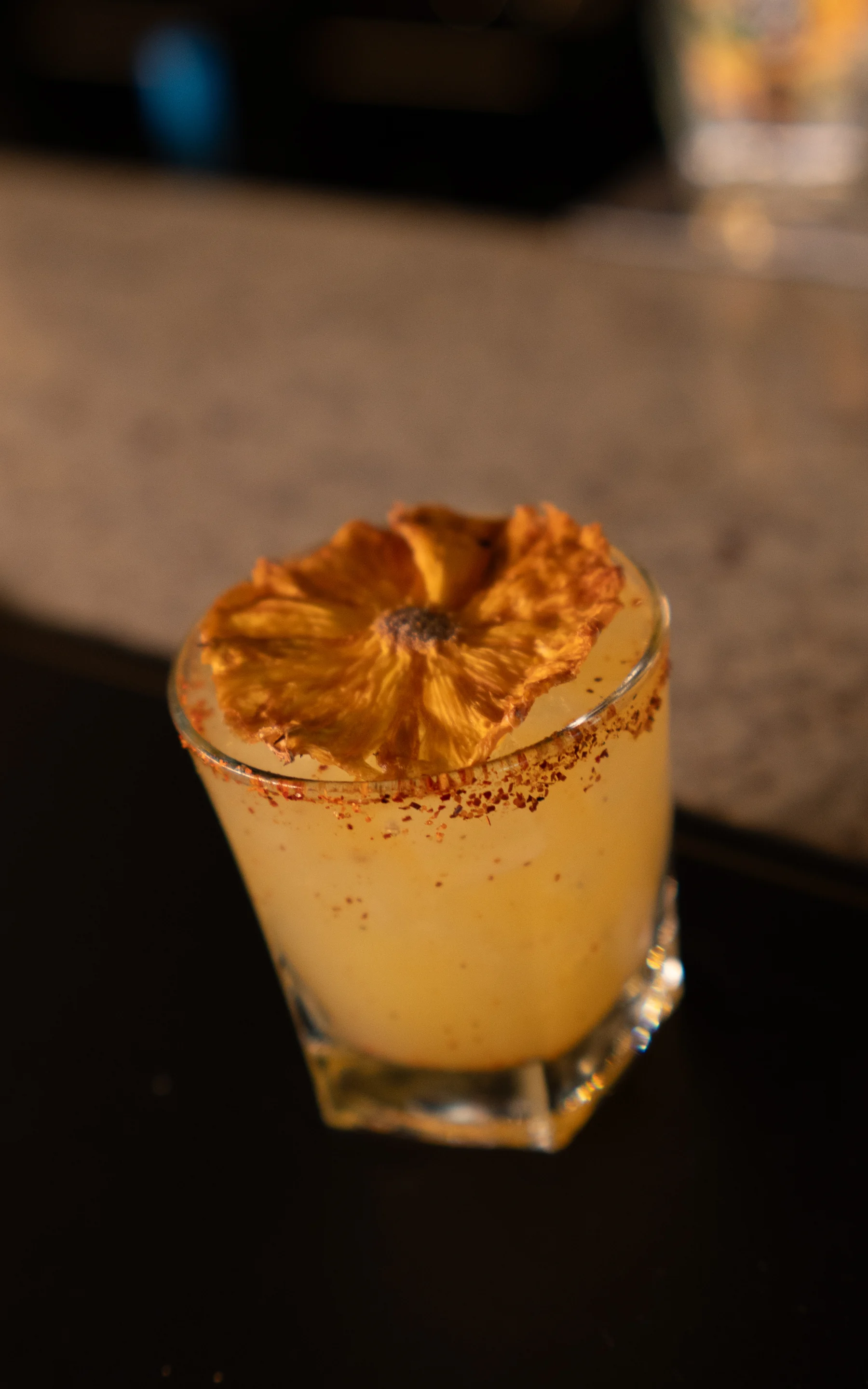 A golden cocktail finished with a dried citrus garnish